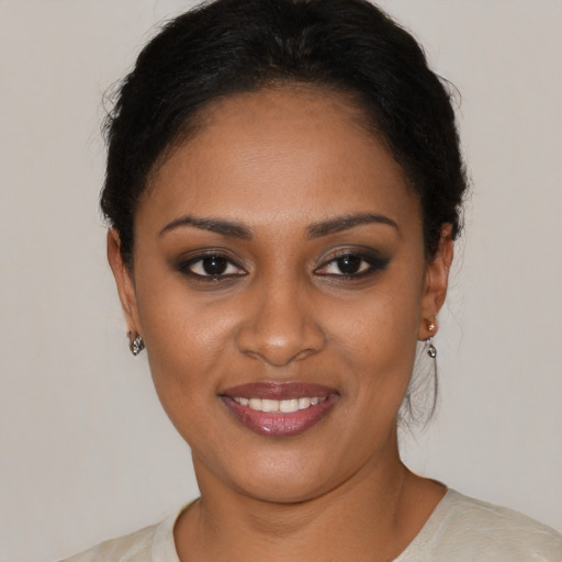 Joyful black young-adult female with short  black hair and brown eyes