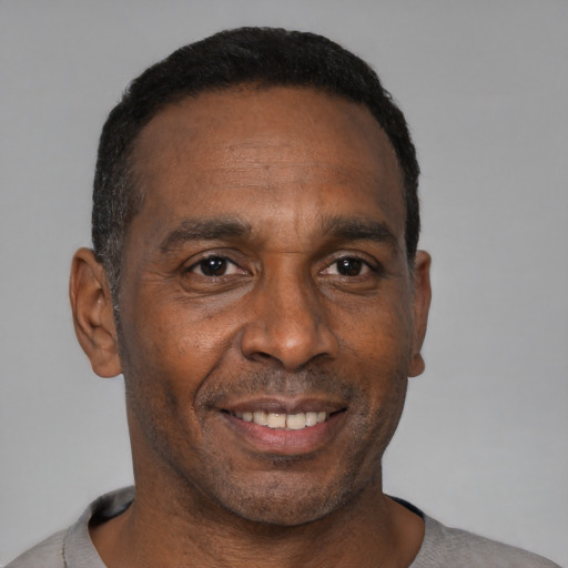 Joyful black adult male with short  black hair and brown eyes