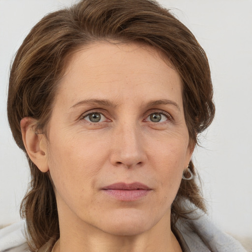 Joyful white adult female with medium  brown hair and grey eyes