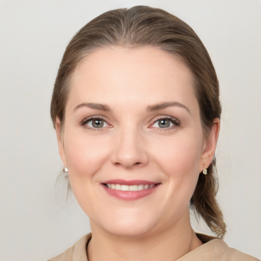 Joyful white young-adult female with medium  brown hair and grey eyes