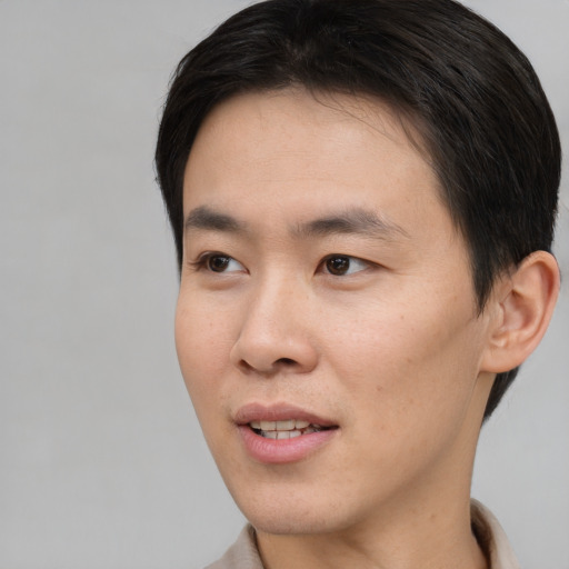 Joyful asian young-adult male with short  black hair and brown eyes