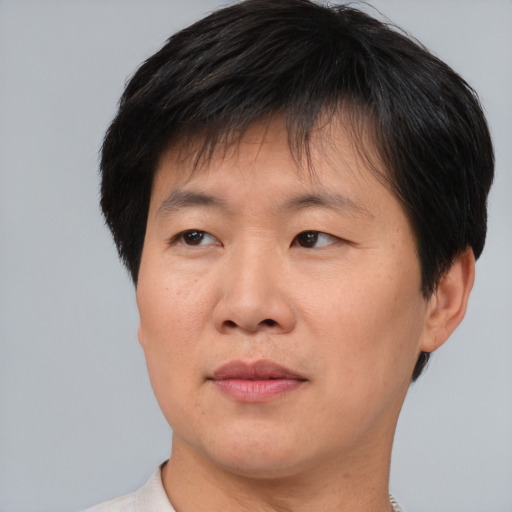 Joyful asian adult male with short  brown hair and brown eyes