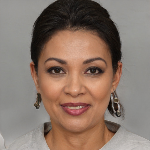 Joyful latino adult female with medium  brown hair and brown eyes