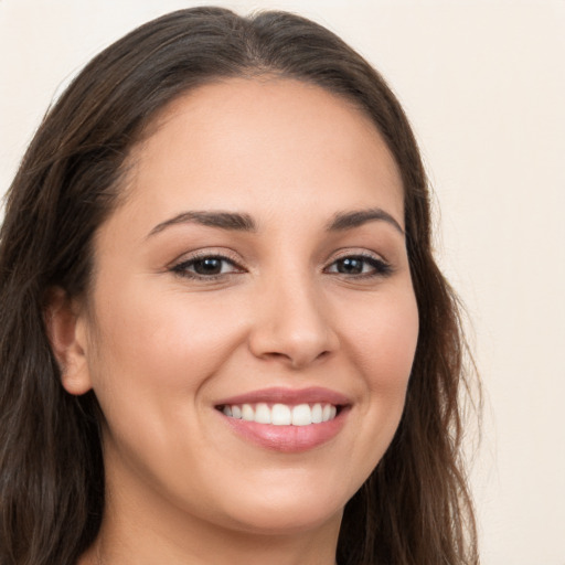 Joyful white young-adult female with long  brown hair and brown eyes