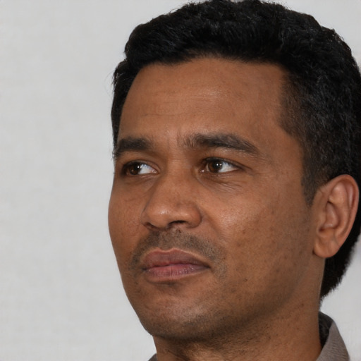 Neutral black adult male with short  black hair and brown eyes