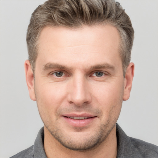 Joyful white adult male with short  brown hair and grey eyes