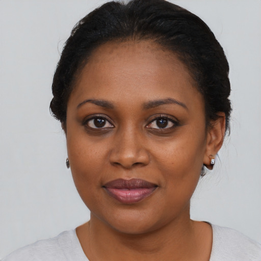 Joyful black young-adult female with short  black hair and brown eyes