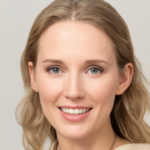 Joyful white young-adult female with long  brown hair and blue eyes