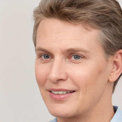 Joyful white adult male with short  brown hair and grey eyes