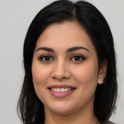 Joyful latino young-adult female with long  brown hair and brown eyes