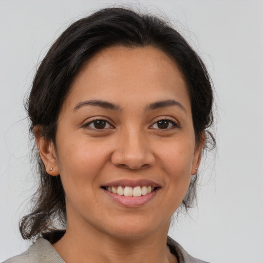 Joyful latino young-adult female with medium  brown hair and brown eyes