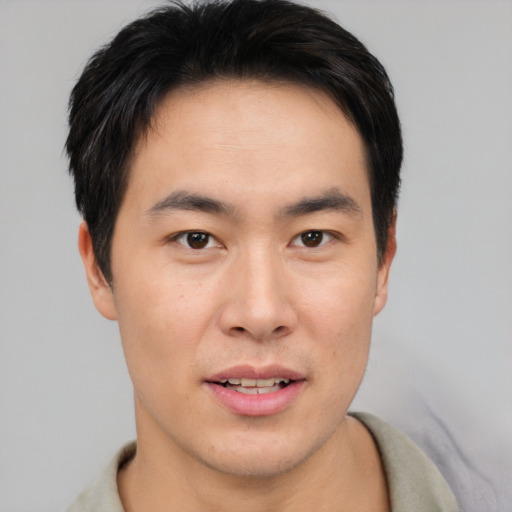 Joyful asian young-adult male with short  brown hair and brown eyes