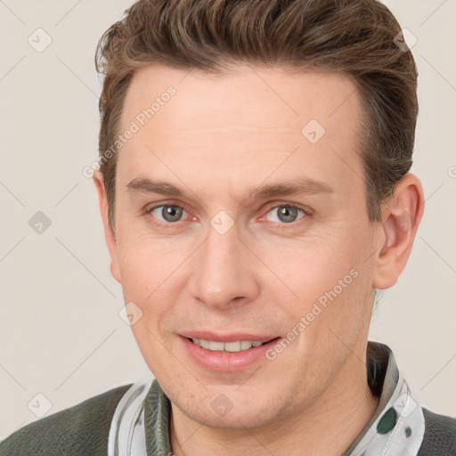 Joyful white adult male with short  brown hair and grey eyes