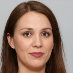 Joyful white adult female with long  brown hair and brown eyes