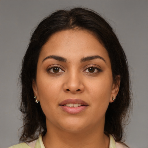 Joyful latino young-adult female with medium  brown hair and brown eyes