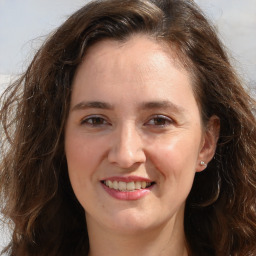 Joyful white adult female with long  brown hair and brown eyes