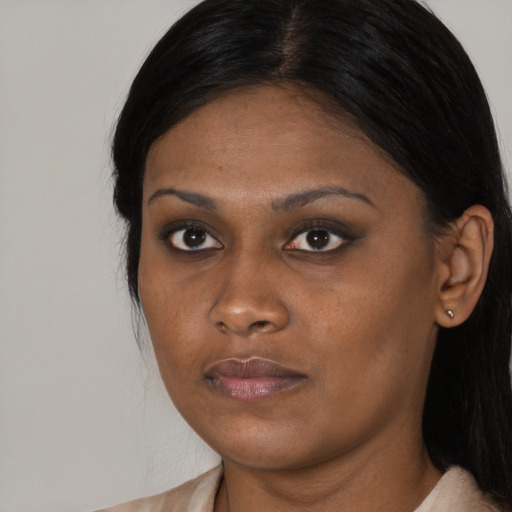 Joyful black young-adult female with long  black hair and brown eyes