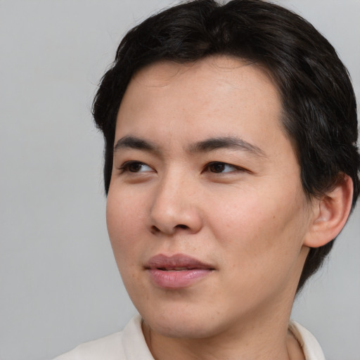 Joyful asian young-adult male with medium  brown hair and brown eyes