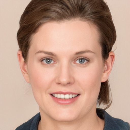 Joyful white young-adult female with medium  brown hair and grey eyes