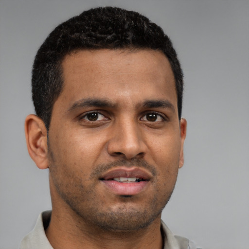 Joyful black young-adult male with short  brown hair and brown eyes