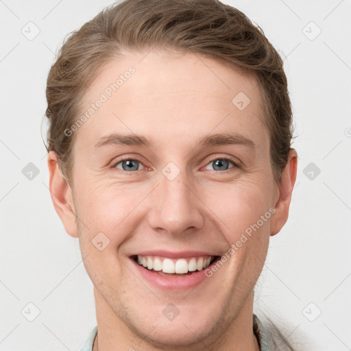 Joyful white young-adult male with short  brown hair and grey eyes