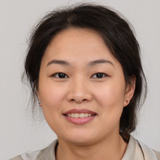 Joyful asian young-adult female with medium  brown hair and brown eyes