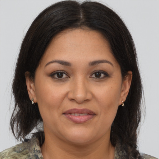 Joyful latino adult female with medium  brown hair and brown eyes