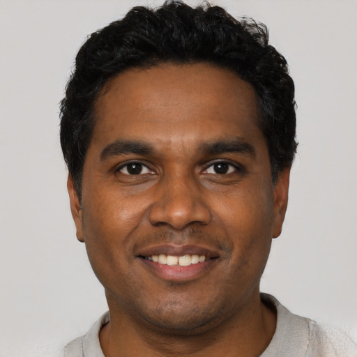 Joyful black young-adult male with short  black hair and brown eyes
