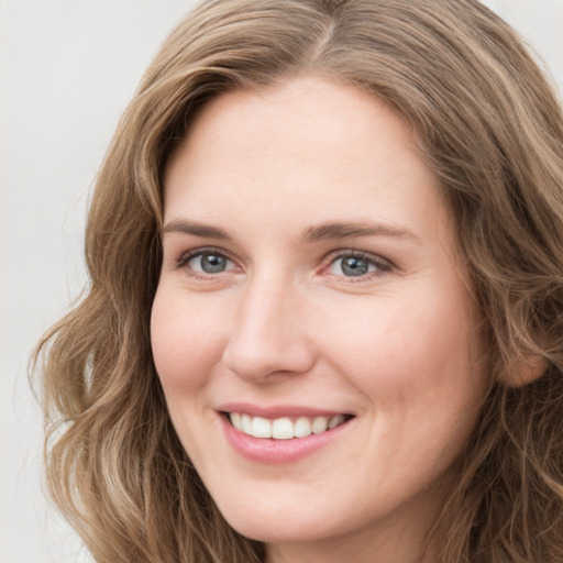 Joyful white young-adult female with long  brown hair and green eyes