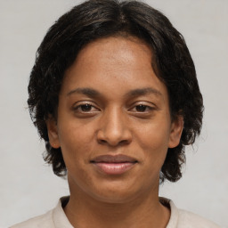 Joyful black adult female with medium  brown hair and brown eyes