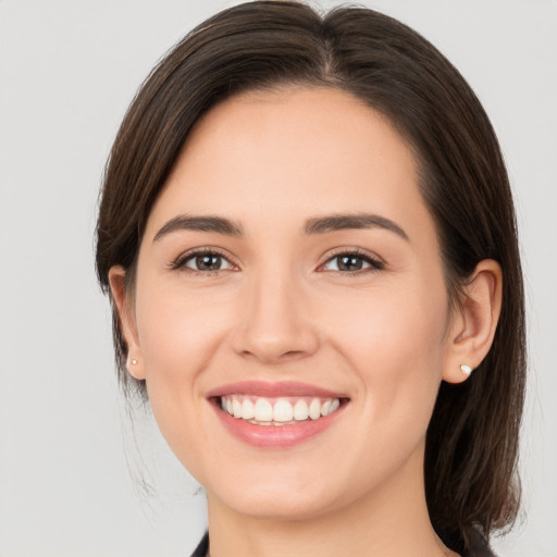 Joyful white young-adult female with medium  brown hair and brown eyes