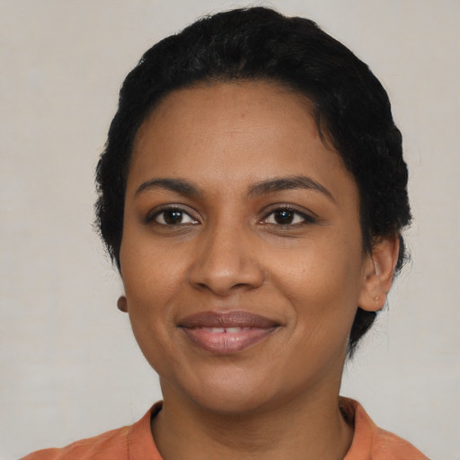 Joyful black young-adult female with short  black hair and brown eyes