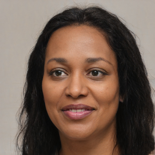 Joyful black adult female with long  brown hair and brown eyes