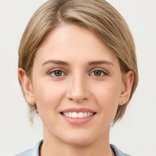 Joyful white young-adult female with medium  brown hair and grey eyes