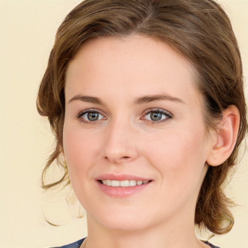 Joyful white young-adult female with medium  brown hair and green eyes