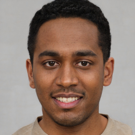 Joyful black young-adult male with short  brown hair and brown eyes