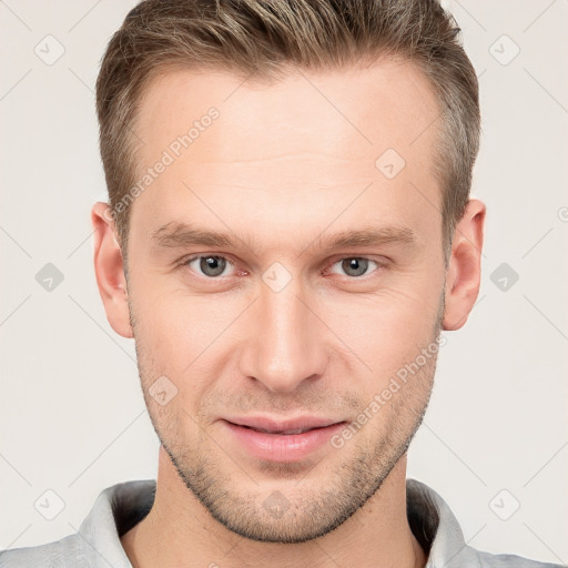 Joyful white young-adult male with short  brown hair and grey eyes