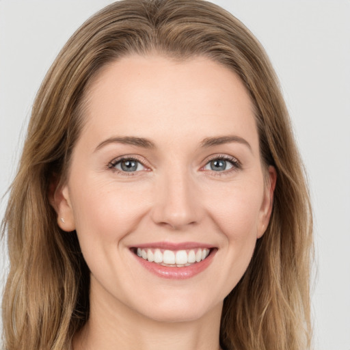 Joyful white young-adult female with long  brown hair and grey eyes