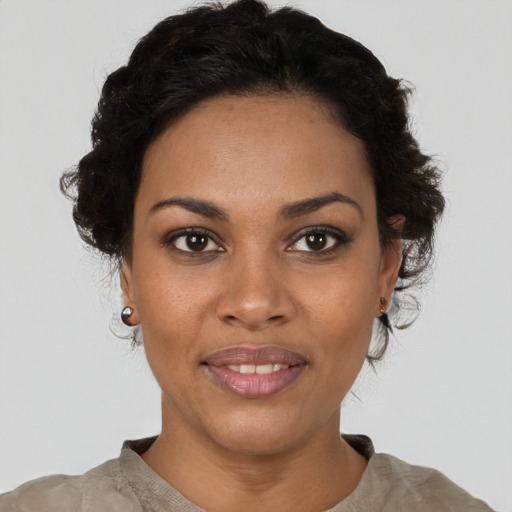 Joyful black young-adult female with short  brown hair and brown eyes
