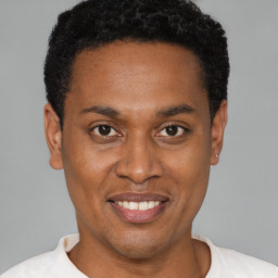 Joyful latino young-adult male with short  brown hair and brown eyes