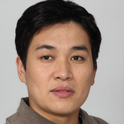 Joyful asian young-adult male with short  black hair and brown eyes