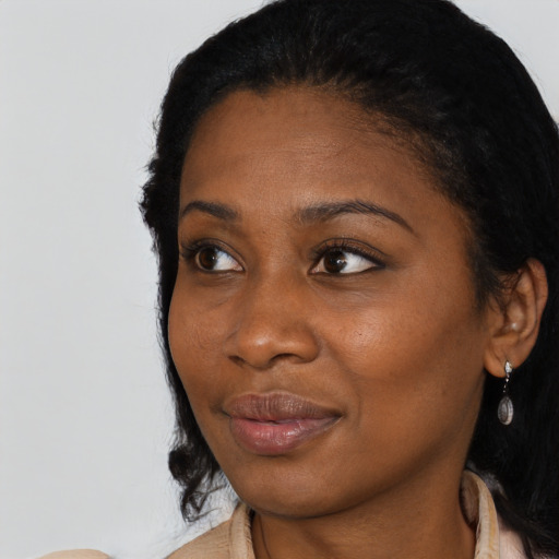 Joyful black young-adult female with long  black hair and brown eyes