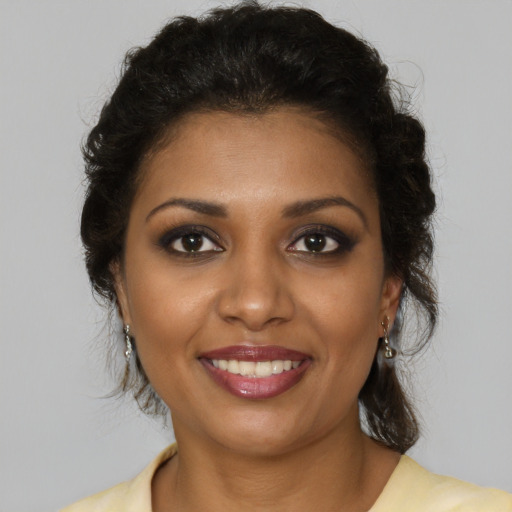 Joyful black young-adult female with medium  brown hair and brown eyes