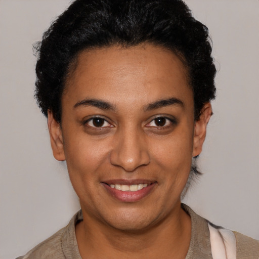 Joyful latino young-adult female with short  black hair and brown eyes