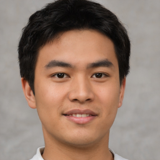 Joyful asian young-adult male with short  brown hair and brown eyes
