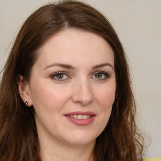 Joyful white young-adult female with long  brown hair and green eyes