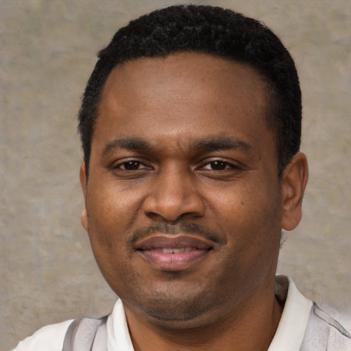 Joyful black young-adult male with short  black hair and brown eyes