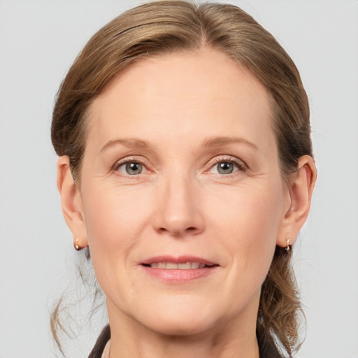 Joyful white adult female with medium  brown hair and grey eyes