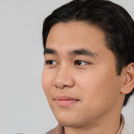 Joyful white young-adult male with short  black hair and brown eyes