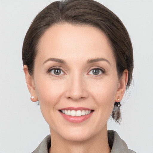 Joyful white young-adult female with medium  brown hair and grey eyes